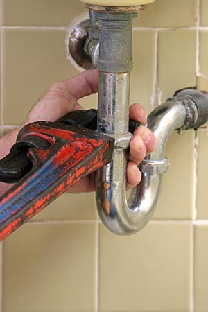 one of our plumbers is repairing a sink drain